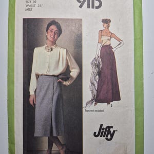 May include: A Simplicity 9113 sewing pattern envelope for a size 10 miss with a 25 inch waist. The green and white package features illustrations of a long grey wrap skirt and a long dark maroon skirt, with the text Jiffy printed on the front.