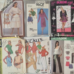 May include: A collection of vintage sewing pattern envelopes from brands like Simplicity, McCall's, and Butterick. The patterns feature illustrations of various clothing designs, including dresses, tops, and pants. The envelopes are in various colors and sizes.