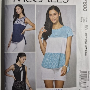 May include: McCall's sewing pattern M7600 featuring three different top designs. The pattern includes sizes 18W-24W. The cover shows images of the finished tops, including a navy blue top with white accents and a white and blue top.