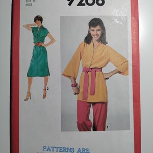May include: Simplicity sewing pattern number 9268 for a miss size 14. The pattern includes two outfits: a green dress with a collar and a yellow top with a pink sash and matching pants. The text "Patterns are not returnable" is printed at the bottom of the pattern.