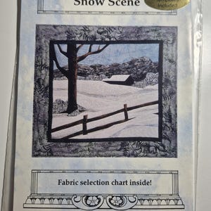 May include: A package featuring a "Snow Scene" iron-on template. The image depicts a winter landscape with a snow-covered field, a tree, and a fence. The package includes a fabric selection chart.