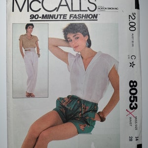May include: McCall's 90-Minute Fashion sewing pattern, number 8053, for a size 14, 28-inch waist. The pattern includes instructions for making a pair of shorts. The model is wearing a white top and green and brown floral shorts.