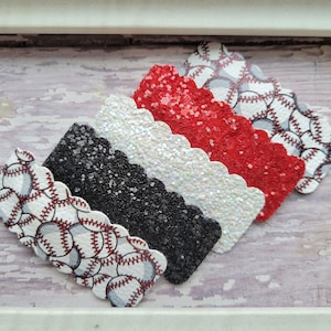 May include: Four scalloped glitter hair clips in black, white, red, and a baseball print.