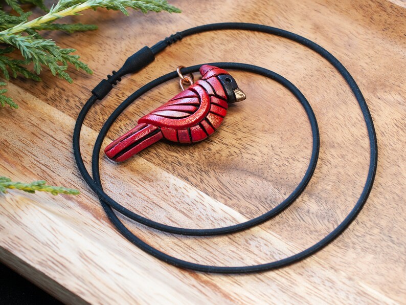 Photo shows 1 bright red mini cardinal mosaic pendant on a black cords with snap closure.