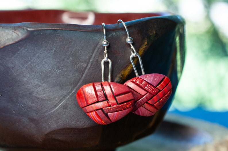 Photo shows bright red dangle mosaic earrings in an inverted triangle shape. The wires are shiny Sterling silver.