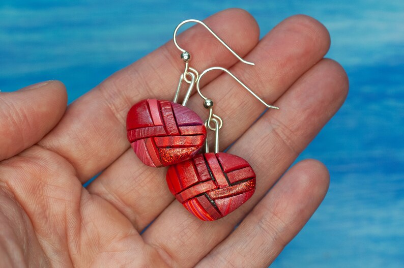 Photo shows bright red dangle mosaic earrings in an inverted triangle shape. The wires are shiny Sterling silver.