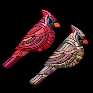 Photo shows two Mosaic Cardinal Brooches on a black background. On the left is a red male. The neutral female is on the right.