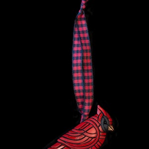 Photo shows bright red cardinal mosaic ornament on a red plaid ribbon.