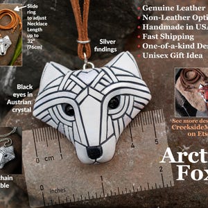White Arctic fox necklace made in mosaic style is shown from the front. Pendant hangs from an adjustable tan leather cord. Eyes are sparkling black crystals. Text is added to show all of the unique details of this piece.