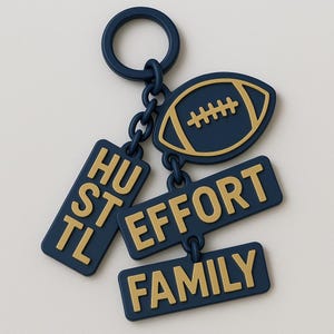 May include: A navy blue keychain with a football-shaped charm and three rectangular charms. The football charm has gold-colored details. The rectangular charms read "HUSTLE", "EFFORT", and "FAMILY" in gold lettering.