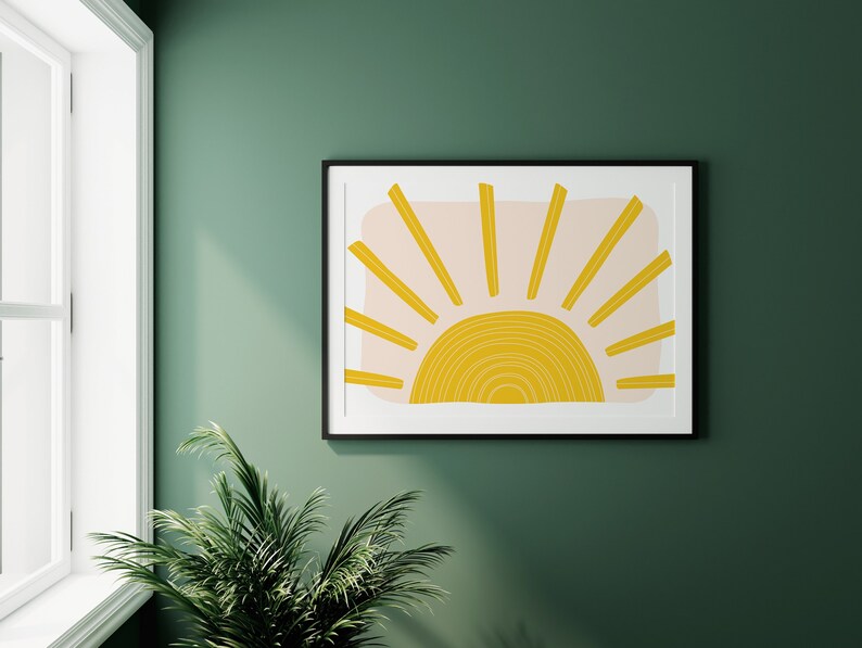 May include: A framed print of a stylised sun with yellow and peach colours on a green wall.