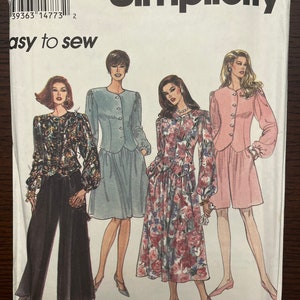 May include: Simplicity sewing pattern number 14773, easy to sew, featuring three women's outfits. The first outfit is a black and white patterned blouse with black wide-legged pants. The second outfit is a light blue jacket with a light blue skirt. The third outfit is a pink jacket with a floral skirt.
