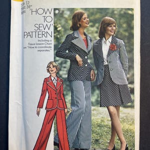 May include: Vintage Simplicity sewing pattern number 6103 for a women's suit. The pattern includes instructions on how to coordinate separates. The pattern is for sizes 12 and 34 inches bust. The pattern shows three women wearing different versions of the suit. One woman is wearing a red suit with a white collar and trim. Another woman is wearing a black and white polka dot suit with a white collar. The third woman is wearing a black and white striped suit with a white collar.