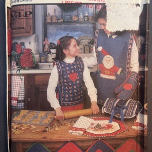 May include: A Simplicity Crafts pattern for making Christmas-themed kitchen accessories. The pattern includes instructions for making a red and white Santa Claus oven mitt, a red and white heart-shaped pot holder, a red and white star-shaped pot holder, a red and white apple-shaped pot holder, and a green and white Christmas tree-shaped pot holder.