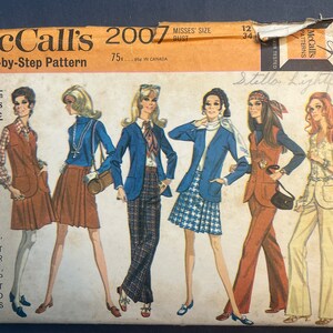 May include: McCall's 2007 Step-by-Step Pattern sewing pattern for misses' jacket, vest, wrap skirt, and trousers. The pattern features five different looks, including a blue blazer with a plaid skirt, a brown waistcoat with a brown skirt, and a brown waistcoat with brown trousers.