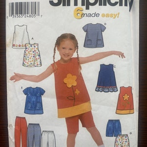 May include: Simplicity sewing pattern number 9648 for making children's clothing. The pattern includes instructions for making a dress, shorts, and trousers. The pattern is for sizes 3-7.