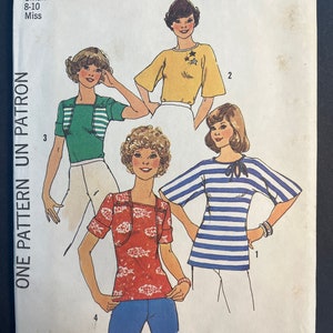 Peut inclure: Un patron de couture pour quatre hauts différents, avec des instructions pour les tailles 8-10. Le patron est uniquement pour les tricots extensibles. Le patron est de Simplicity et porte le numéro 7398.
