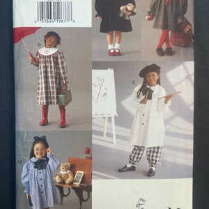 May include: A sewing pattern for children's clothing. The pattern includes five different designs: a red and black plaid dress, a black dress with a white collar, a green dress with a red collar, a white dress with a black and white plaid skirt, and a white dress with a black and white striped skirt. The pattern is for sizes 2-3-4. The pattern is from Vogue for Me.