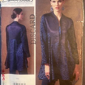 May include: A vintage sewing pattern showing a woman in a dark blue jacket with a distinctive wave design. The pattern is labelled "Zandra Rhodes" and "Vogue Patterns Designer Original". The word "DISCARD" is printed on the pattern.