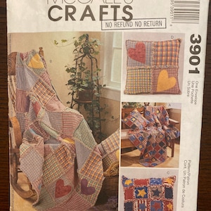 May include: McCall's Crafts pattern 3901 for a patchwork quilt and pillows. The pattern includes instructions for making a quilt with a heart design and two pillows with a heart and star design. The pattern is printed on a white background with a black border.
