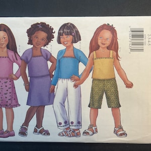 May include: A sewing pattern for girls' clothing, sizes 2-3-4-5. The pattern includes three different outfits: a pink top with a floral skirt, a purple top with a skirt, and a blue top with white trousers. The pattern is from Butterick, and is labelled "Fast & Easy".