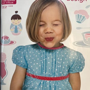 May include: The cover of a magazine titled "OTTOBRE design" features a young girl wearing a light blue dress with white polka dots and a red velvet belt. The magazine cover includes the text "OTTOBRE kids fashion 62-170 cm" and "Spring 1/2008".