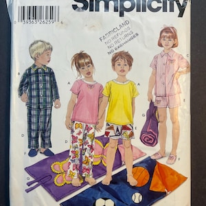 May include: A sewing pattern for children's pajamas and a sleeping bag. The pattern is for sizes 3-8. The pattern includes a plaid pajama set, a butterfly print pajama set, a striped pajama set, and a sleeping bag with a soccer ball and basketball design.