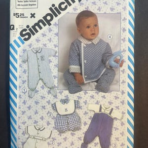 May include: Simplicity pattern 6256 for children's sleepwear. The pattern includes various baby outfits, including a striped onesie, a polka-dot outfit, a bib and shorts set, and a purple overall. The image features a baby wearing a polka-dot outfit.