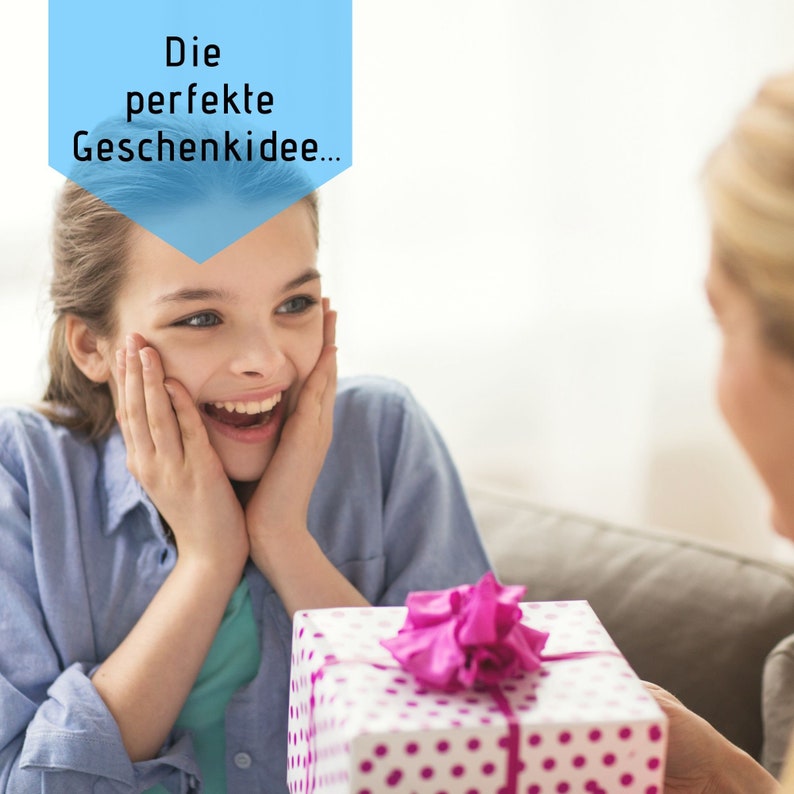 Puede incluir: Una persona joven se sorprende y se emociona al recibir un regalo. El regalo est&aacute; envuelto en papel blanco con lunares rosas y un lazo rosa. El texto sobre la cabeza de la persona dice "Die perfekte Geschenkidee..."