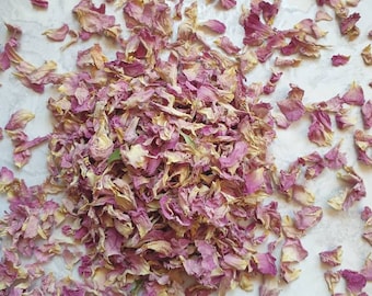 Peut inclure: Un tas de pétales de rose séchées, de couleur rose clair avec un léger jaunissement, sur un fond blanc.