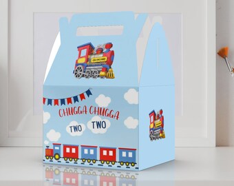 May include: Blue and red train-themed party favour box with a handle. The box features a cartoon train with the text "Chugga Chugga Two Two".