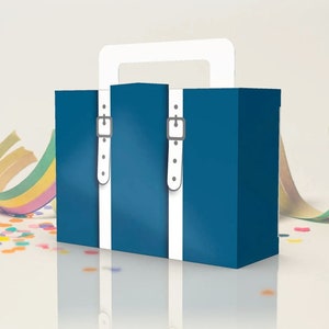May include: A blue cardboard suitcase with white straps and a white handle. The suitcase is sitting on a white surface with colorful confetti scattered around it.