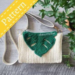 May include: Cream crochet bag with a green leaf design. The bag has a white strap and gold rings. The text "Pattern" is in a yellow banner. The text "shea.crochet" is on the green leaf.