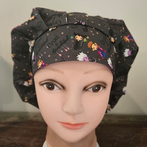 May include: Black scrub hat with a print of the Evil Queen from Snow White. The print includes the text "Cruel & Beautiful".
