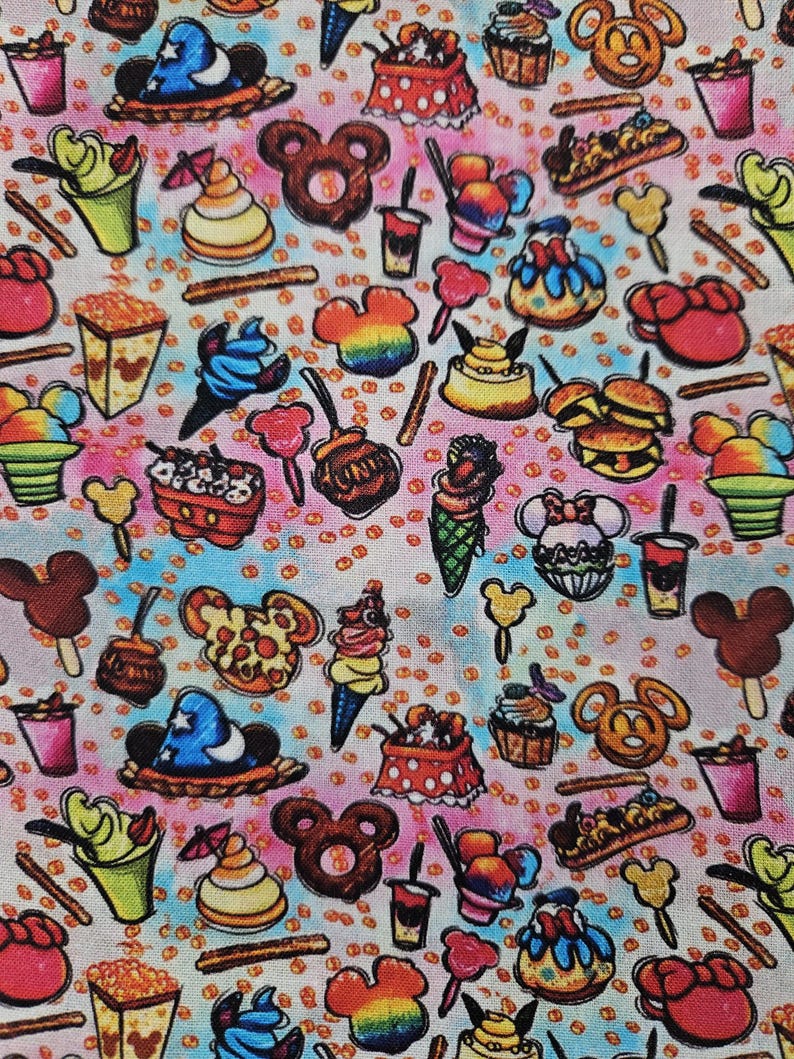 May include: A colorful fabric with a repeating pattern of various Disney-themed food items, including Mickey Mouse ears, ice cream cones, popcorn buckets, and pretzels. The background is a light blue and pink tie-dye pattern.