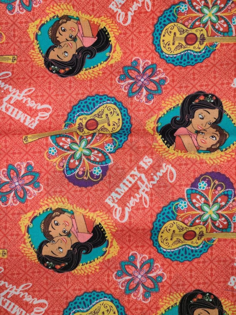 May include: A red fabric with a repeating pattern of a guitar, flowers, and two women with long dark hair. The text "Family is Everything" is repeated throughout the fabric.