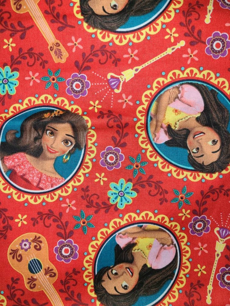 May include: Red fabric with a repeating pattern of a cartoon princess with brown hair and a yellow dress. The pattern also includes flowers, vines, and a guitar.