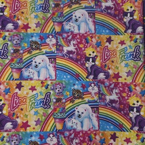 May include: A colorful fabric featuring a repeating pattern of rainbows, stars, and cartoon animals. The design includes polar bears, cats, dogs, unicorns, and the text "Lisa Frank" in a playful font. The background is a mix of bright colors.