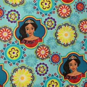 May include: A turquoise fabric with a repeating pattern of colorful flowers, stars, and a princess with a crown. The princess is wearing a red dress and has dark hair.