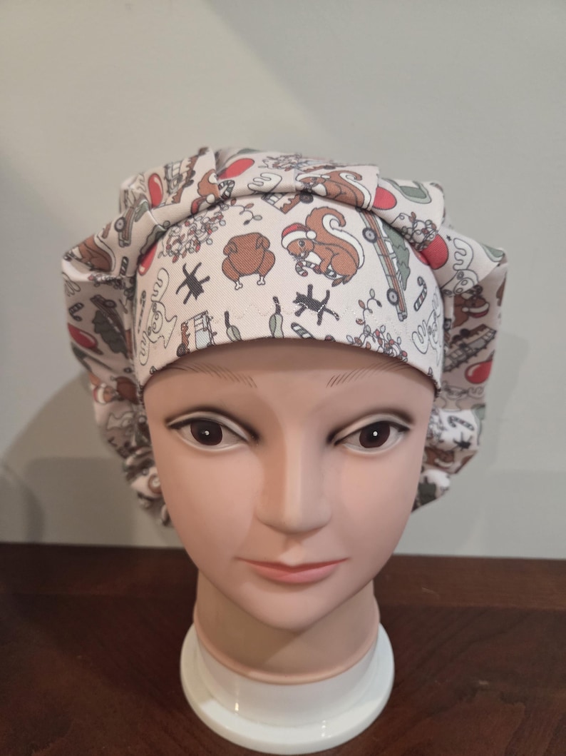May include: A scrub cap featuring a festive holiday print on a light background. The pattern includes illustrations of squirrels wearing Santa hats, roasted turkeys, candy canes, and vintage trucks carrying Christmas trees in red, green, and brown.