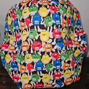 Pu&ograve; includere: Tessuto nero con un motivo ripetuto di personaggi M&M's colorati. I personaggi indossano tutti guanti bianchi e hanno espressioni facciali diverse.