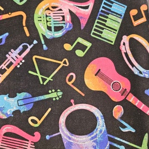 Può includere: Un tessuto nero con un motivo di strumenti musicali colorati. Gli strumenti includono una chitarra, un violino, una batteria, una tromba, un'arpa, un corno francese, un pianoforte e una nota musicale.