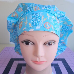 May include: A blue and white patterned surgical scrub hat with the text "Young Wild + Gluten Free" repeated throughout.