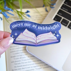 May include: A blue and purple sticker with a book and the text "meet me at midnight".