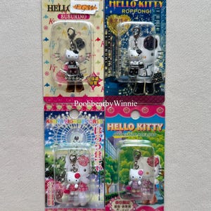 Può includere: Quattro portachiavi Hello Kitty in confezione blister di plastica trasparente su supporto di cartone. Ogni portachiavi presenta una piccola figura di Hello Kitty con un moschettone in metallo. La confezione mostra testo e grafiche in giapponese.