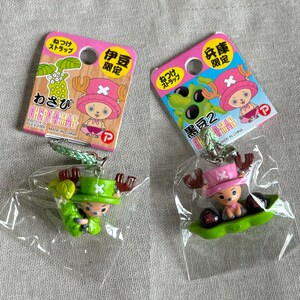 May include: Two One Piece Chopper Man keychains. One is green and the other is pink. Each keychain is attached to a pink and colorful tag with Japanese text. The keychains are in clear plastic packaging.