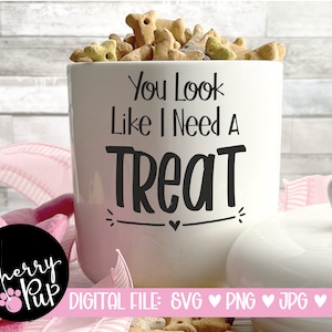 May include: White ceramic dog treat jar with the text "You Look Like I Need A Treat" in black lettering. The jar is filled with dog treats.