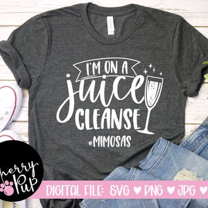 May include: A gray t-shirt with the text "I'm on a juice cleanse #MIMOSAS" in white. A glass of champagne is pictured next to the text.