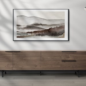 May include: A framed watercolor painting of a landscape with brown and gray hills and a black floor lamp with a black shade.