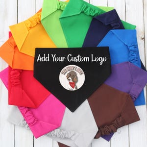 May include: A variety of colors of dog bandanas, including orange, green, blue, purple, brown, pink, and gray. The bandanas are arranged in a circle with a black bandana in the center. The black bandana has the text "Add Your Custom Logo" and a logo with a dog and the text "The Woof Lounge".